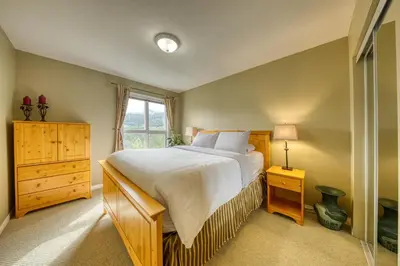 a bedroom with a large bed and a window at The Peaks 3 Bedroom Mountain View Condo in Radium Hot Springs