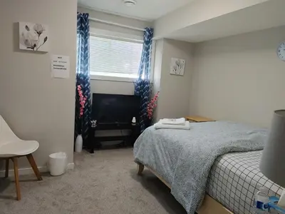 a small bedroom with a bed and a television at Genesis Townhouse in Calgary