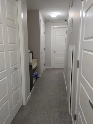 a hallway with white doors and a room with a desk at Genesis Townhouse in Calgary