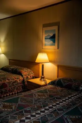 a hotel room with two beds and a lamp at Talbot Arm Motel in Destruction Bay