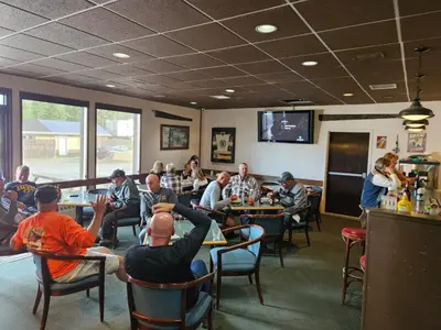 a group of people sitting at tables in a restaurant at Talbot Arm Motel in Destruction Bay