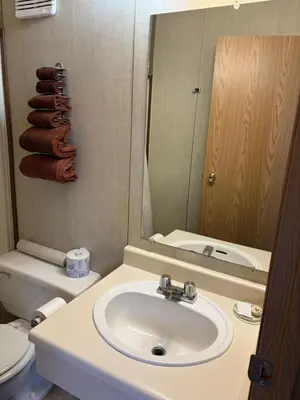 a bathroom with a sink and a toilet and a mirror at Talbot Arm Motel in Destruction Bay