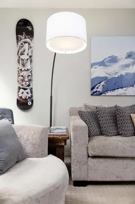 a living room with a couch and a snowboard on the wall at Spacious 3BR Condo in Whistler in Whistler