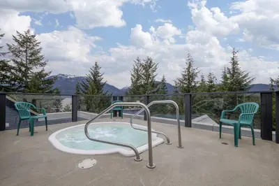 a hot tub on a balcony with two chairs at Spacious 3BR Condo in Whistler in Whistler