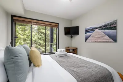 a bedroom with a large bed with a large window at Spacious 3BR Condo in Whistler in Whistler