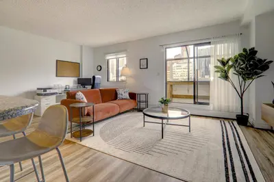 a living room with a couch and a table at Stylish DT Views at Stampede w Free Parking and AC in Calgary