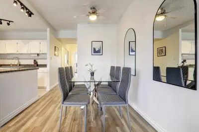 a dining room with a glass table and chairs at Stylish DT Views at Stampede w Free Parking and AC in Calgary