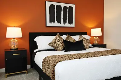 a bedroom with a bed with orange walls and two lamps at Elegant Retreat with King Beds,Golf,Disney,Near WEM in Edmonton