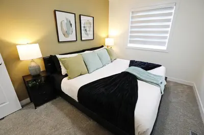 a bedroom with a large bed with pillows and a window at Elegant Retreat with King Beds,Golf,Disney,Near WEM in Edmonton
