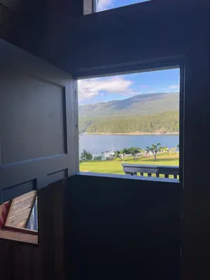 a window in a room with a view of a lake at Gracies Grotto Cabin in Powell River