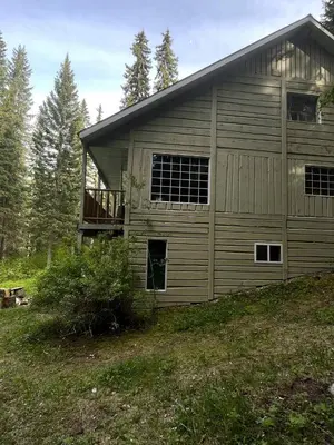 a large metal building with a garage at Rustic Executive Cabin at Beaverfoot in Parson