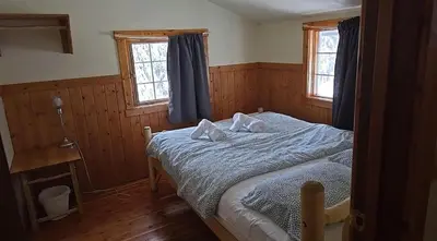 a bedroom with a bed with two pillows on it at Rustic Woodland Cabin at Beaverfoot in Parson