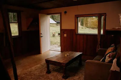a living room with a couch and a coffee table at Rustic Basic Cabin at Beaverfoot in Parson