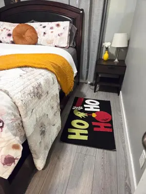 a bedroom with a bed and a welcome rug on the floor at Spacious & Comfy Upper Floor 3BR Suite in Detached House in Calgary