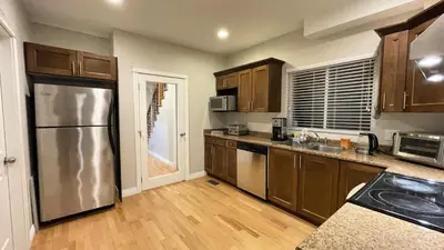 a kitchen with a stainless steel refrigerator and wooden cabinets at James house J&J Chilliwack in Chilliwack