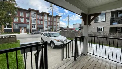 a porch with a car parked on a street at James house J&J Chilliwack in Chilliwack