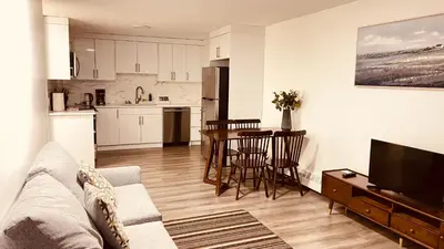a living room with a couch and a table and a kitchen at #202 Cozy Mountain View 2 bedrooms in DT in Canmore
