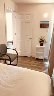 a bedroom with a bed and a chair and a door at #202 Cozy Mountain View 2 bedrooms in DT in Canmore