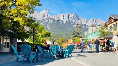 a group of people sitting in chairs on a street at #304 Mountain View 1BR in Canmore DT in Canmore