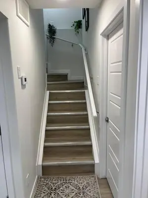 a hallway with a stairway with a white door and a stair at Parkside Basement Suite in Edmonton
