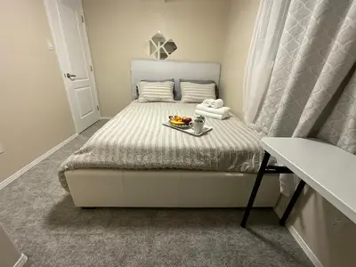 a small bedroom with a bed with a tray of food on it at Cozy Comfort rooms in Nanaimo in Nanaimo