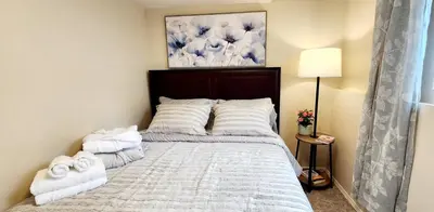 a bedroom with a bed with towels on it at Cozy Comfort rooms in Nanaimo in Nanaimo