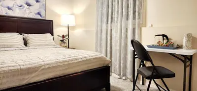 a bedroom with a bed with a desk and a chair at Cozy Comfort rooms in Nanaimo in Nanaimo