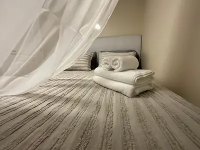 a bedroom with a bed with a curtain and towels at Cozy Comfort rooms in Nanaimo in Nanaimo