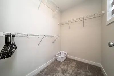 a walk in closet with white walls and a shelf at Beautiful Elegant Home Sleeps 10, Free Parking, Central AC in Edmonton