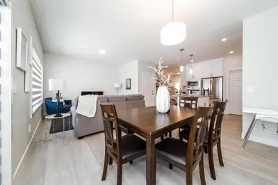 a dining room and living room with a table and chairs at Beautiful Elegant Home Sleeps 10, Free Parking, Central AC in Edmonton