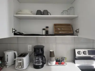a kitchen counter with a coffeemaker and a coffee maker at Luxurious Home in NW Calgary, Free Parking, High Speed Internet, Near Grocery and Airport in Calgary