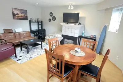 a living room with a wooden table and a couch at Cheerful 2BR suite, onsite free parking CARS or RV in North Vancouver
