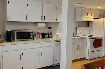 a kitchen with white cabinets and a microwave at Cheerful 2BR suite, onsite free parking CARS or RV in North Vancouver