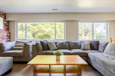 a living room with a couch and a table at Quiet Area Near Downtown Walkable To Cafes in Maple Ridge District Municipality