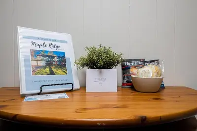 a table with a laptop computer on top of it at Quiet Area Near Downtown Walkable To Cafes in Maple Ridge District Municipality