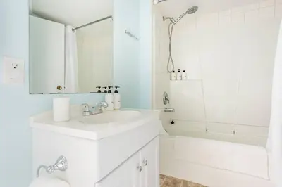 a white bathroom with a sink and a shower at Quiet Area Near Downtown Walkable To Cafes in Maple Ridge District Municipality