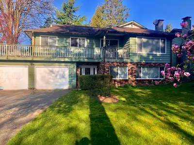 a large green house with a large yard at Quiet Area Near Downtown Walkable To Cafes in Maple Ridge District Municipality