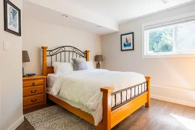 a bedroom with a large bed and a window at Quiet Area Near Downtown Walkable To Cafes in Maple Ridge District Municipality