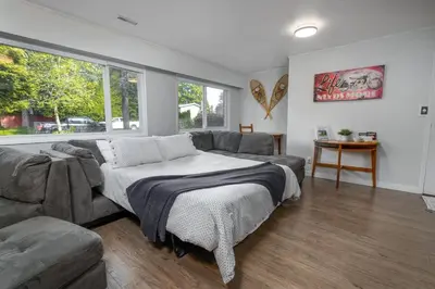 a bedroom with a large bed and a couch at Quiet Area Near Downtown Walkable To Cafes in Maple Ridge District Municipality