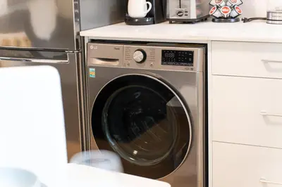 a stainless steel washer and dryer in a kitchen at New Bright Modern Guest Suite in Vancouver in Burnaby