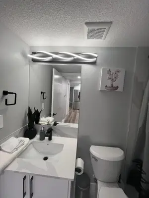 a bathroom with a sink and a toilet and a mirror at Adorable Private Suite in Seton SE, Calgary in Calgary