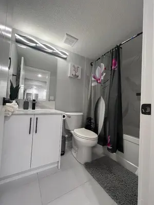 a bathroom with a toilet and a sink and a shower at Adorable Private Suite in Seton SE, Calgary in Calgary