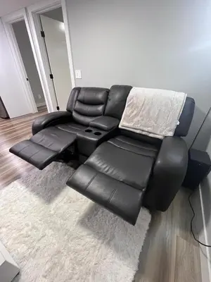 a black leather reclining couch in a living room at Adorable Private Suite in Seton SE, Calgary in Calgary