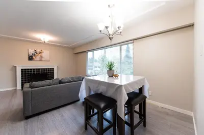 a living room with a table and a couch at Burnaby Metrotown 3 bedroom upstairs in Burnaby