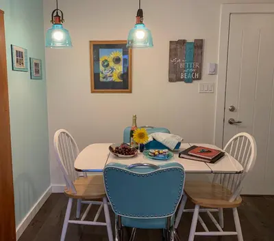 a dining room with a table with chairs and a table and a table at Windslow Guest Suite at Kye Bay in Comox