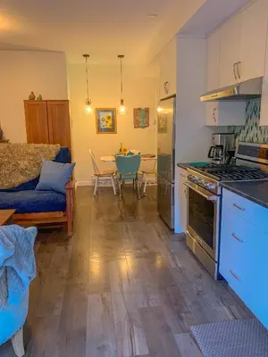 a kitchen and living room with a table and a couch at Windslow Guest Suite at Kye Bay in Comox