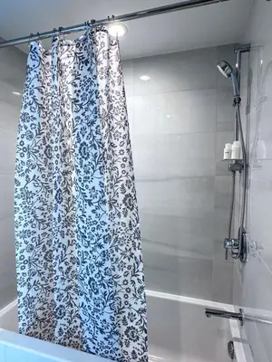a shower curtain in a bathroom next to a tub at Relocation Special-New condo at Metrotown in Burnaby
