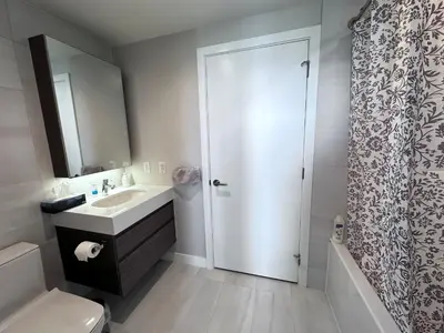 a bathroom with a sink and a toilet and a shower at Relocation Special-New condo at Metrotown in Burnaby