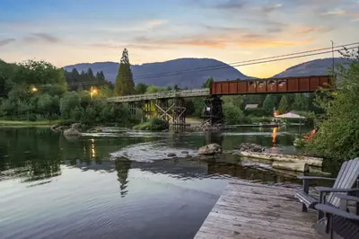 a bridge over a river with a train on it at Riverside by Cowichan Lake Cottages in Lake Cowichan