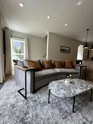 a living room with a couch and a coffee table at Private Hot Tub Ski In Ski Out Sleeps 9 in Panorama